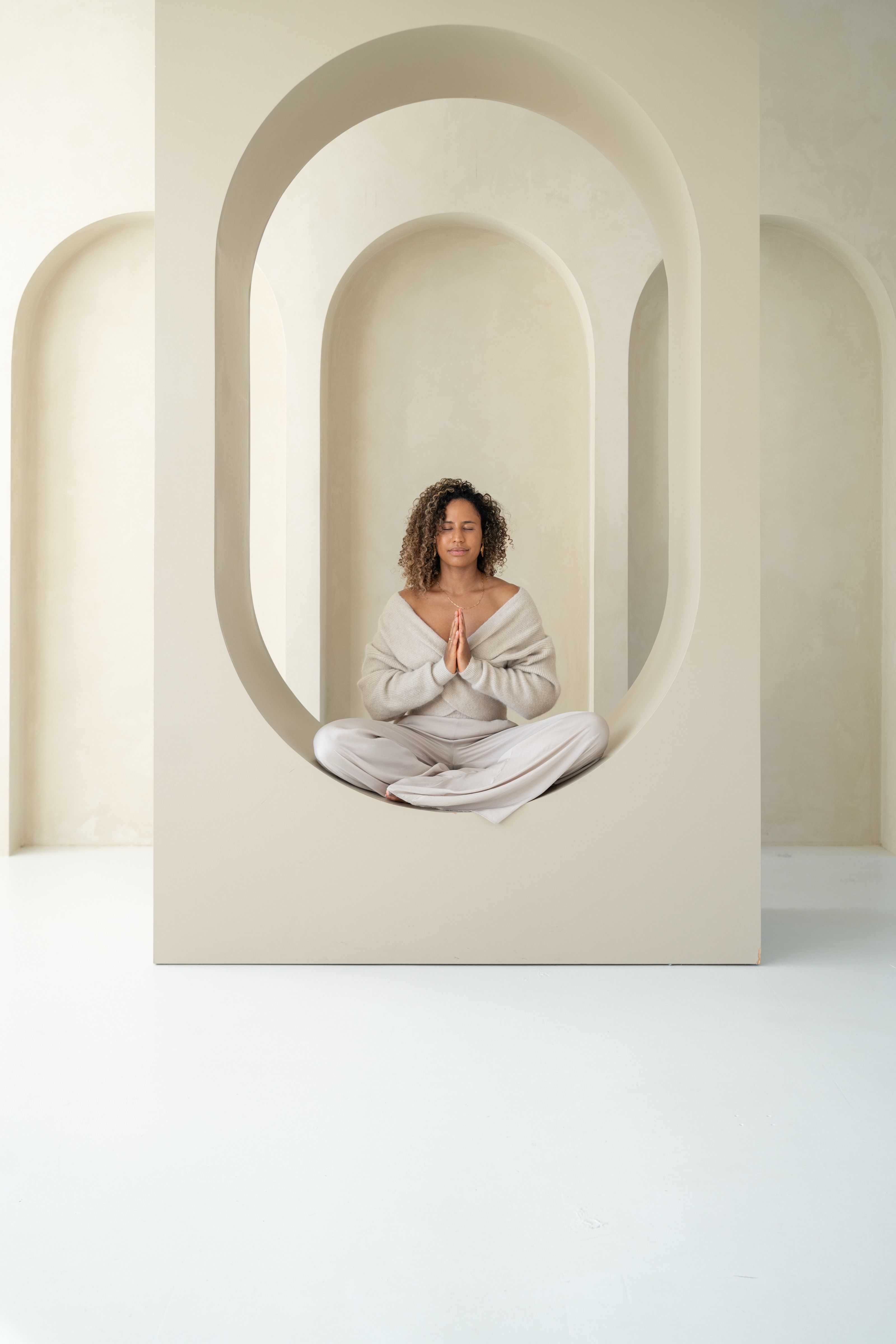 Couro seated in meditation inside an arched studio niche