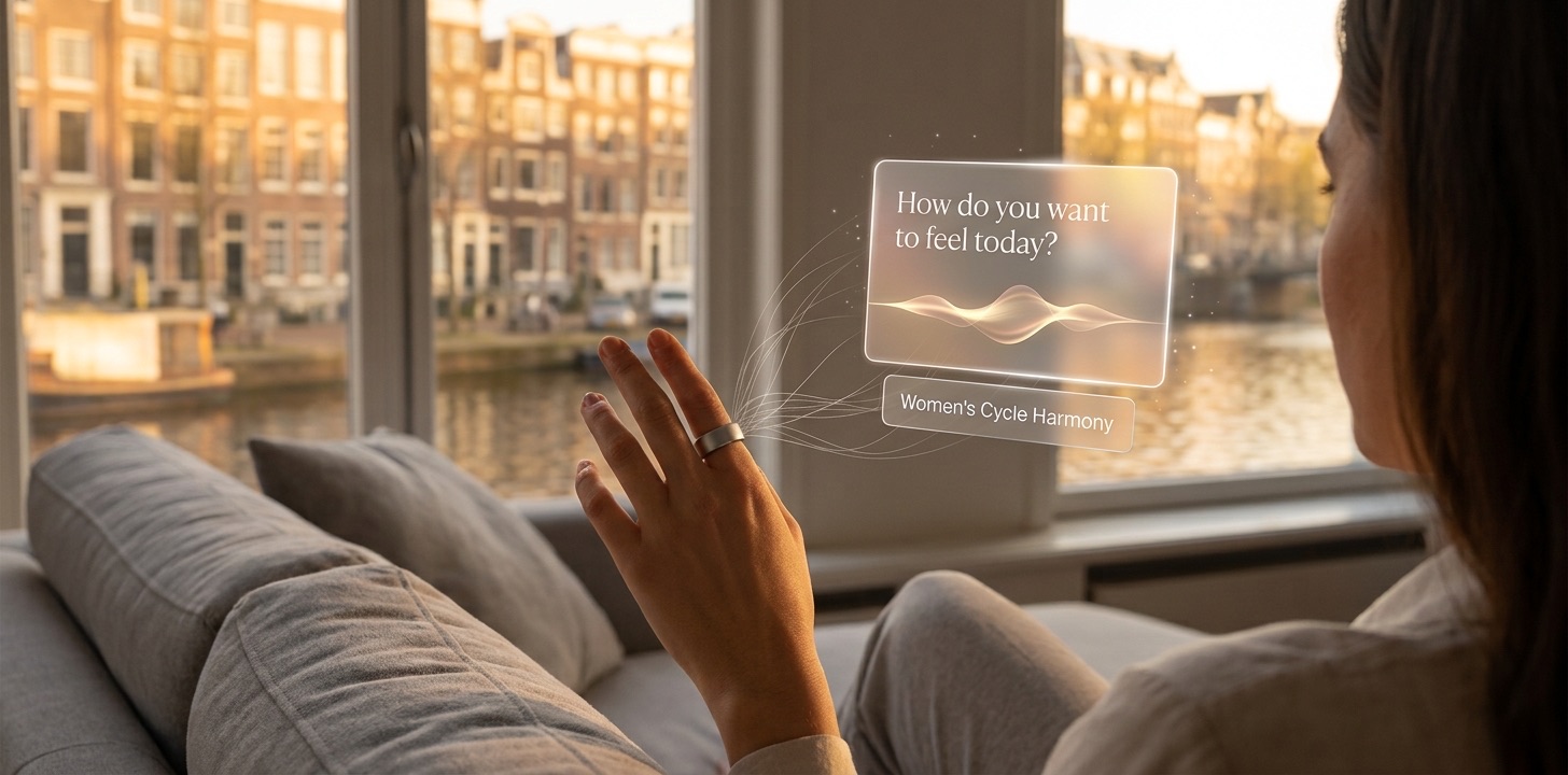 Concept visual: a woman wearing an Ōura ring on a sofa by an Amsterdam canal window, a soft interface floating in front of her asking How do you want to feel today? with a Women’s Cycle Harmony option below it